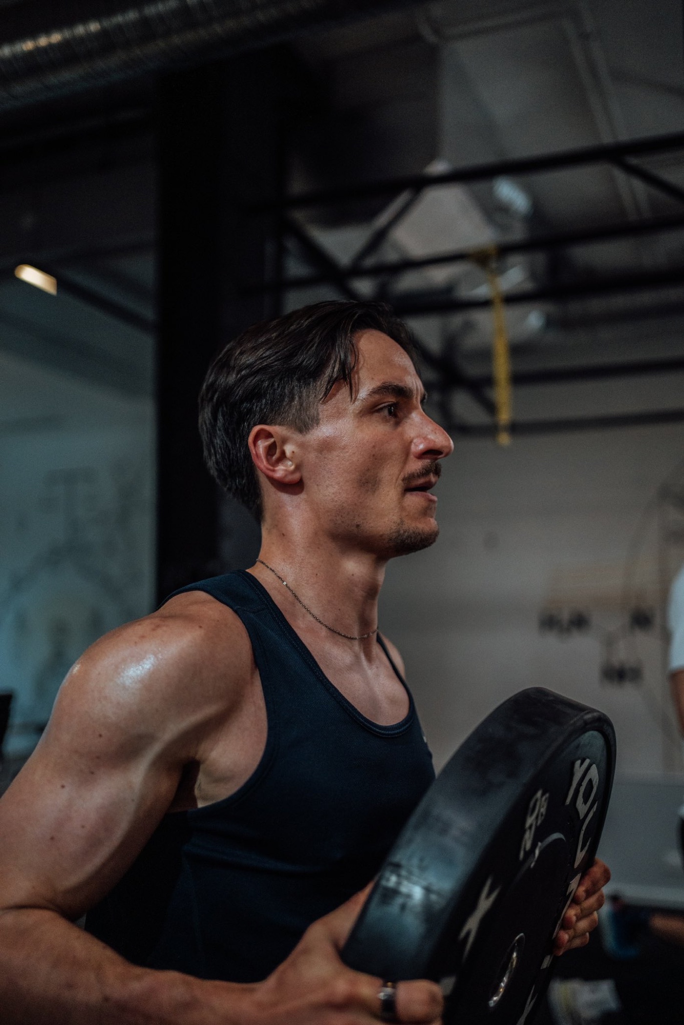 Max Guerois training, holding a weight plate